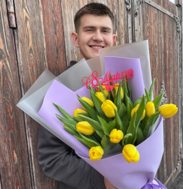 15 жёлтых тюльпанов в сиреневом оформлении 